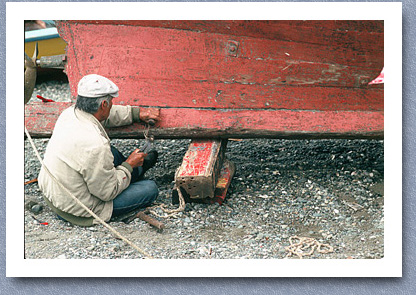 Man repairing fishiing boat, Ancud